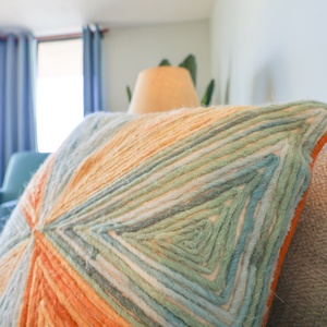 Enjoy the vibrant textures of the decorative pillows on the sofa with a queen sleeper for additional guests