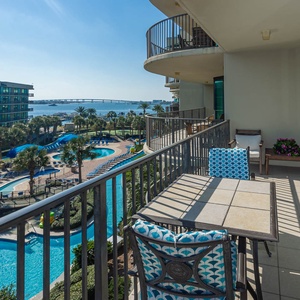 Lounge on the balcony overlooking the refreshing pool, lazy river, stunning bay water, and marina activity
