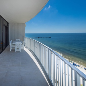 Savor meals at the outdoor dining table while enjoying expansive views of the tranquil waters and beach below