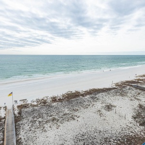 Step onto the boardwalk leading to the beach, where gentle waves meet the shore for a relaxing day by the water