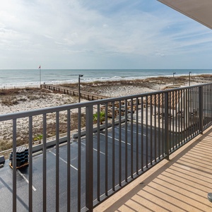 Enjoy a relaxing view of the beach from this balcony, featuring comfortable seating and a serene atmosphere