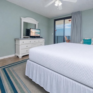 Experience comfort in this serene master bedroom featuring a king bed, dresser, and beachfront balcony access