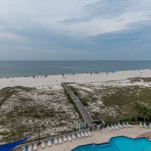 Enjoy the expansive view of the beach with lounge chairs and umbrellas, perfect for a relaxing day in the sun