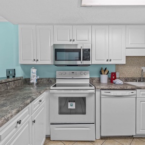 Kitchen featuring stainless appliances and a lovely turquoise accent wall for a cheerful cooking experience