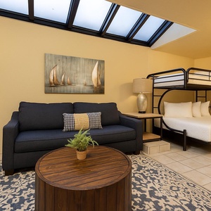 Patio area featuring a dark blue sofa, a wooden coffee table, and a unique twin over double bunk bed setup