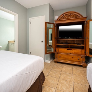 Enjoy restful nights in this inviting guest bedroom with two double beds, a TV, and easy access to the adjoining bathroom
