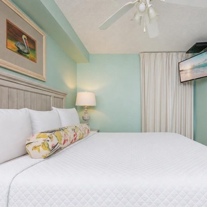 Fluffy pillows invite you to relax in the king suite for a calm movie night after a fun day at the beach