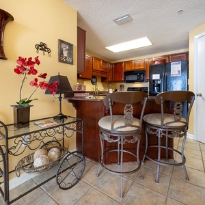 Relax at the stylish bar seating while enjoying the view of the inviting kitchen and its warm decor