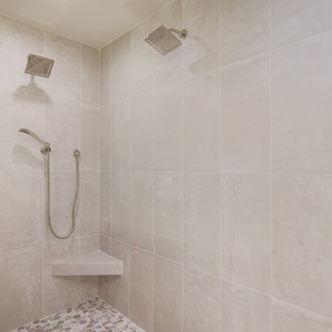 Refreshing walk-in shower in this stylish master bathroom featuring elegant tile and modern rainshower fixtures
