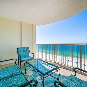 This balcony offers a serene beachfront view, featuring comfortable seating and a relaxing atmosphere