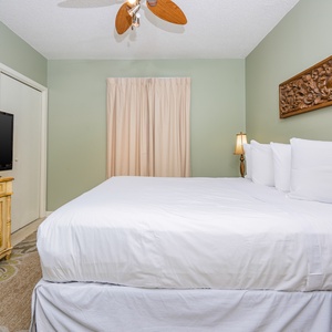 Relax in the inviting guest bedroom featuring a queen bed, a TV, and charming decor for a restful retreat