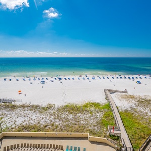 Relax with the view of the serene beach with colorful umbrellas under a bright blue sky, perfect for your beach retreat