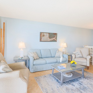 Relax in the bright living area, featuring comfortable seating, decorative accents, and a dining space for shared meals