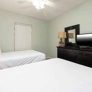 Guest bedroom featuring two queen beds, a dresser, and a TV for your entertainment