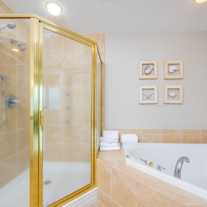Relax in this elegant bathroom featuring a jetted tub, walk-in shower, and coastal-inspired decor for a refreshing retreat