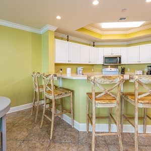 Gather at the breakfast bar on rustic stools while the soft overhead light sets a cozy kitchen mood