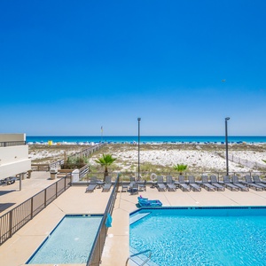 Relax in the inviting pool area, soaking up the sun while enjoying views of the beach just steps away