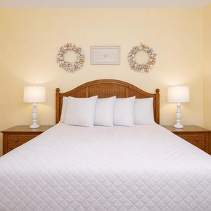 Drift into restful slumber on the plush king bedding, surrounded by warm hues and beach-inspired decor