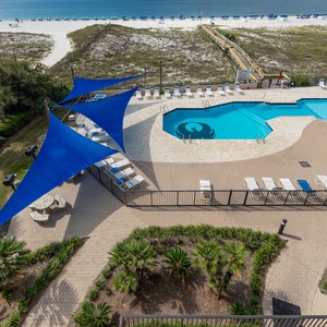 Enjoy the inviting pool area, surrounded by vibrant canopies and lush landscaping, just steps from the beach