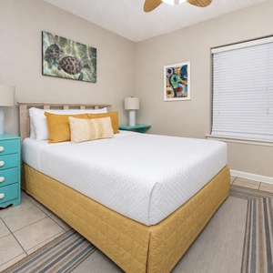 Charming guest bedroom with a comfortable queen bed, colorful accents, and inviting decor