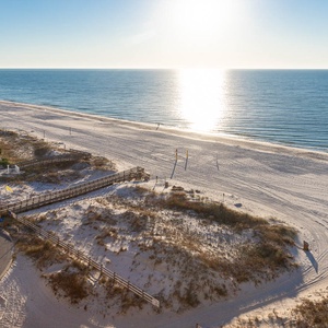 Enjoy a serene view of the sparkling water and white sand beach from the balcony, perfect for relaxation and sunbathing