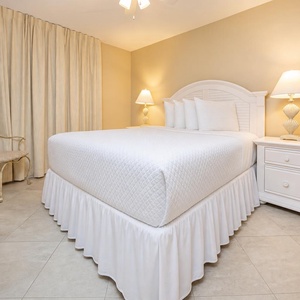 Inviting guest bedroom featuring a comfortable queen bed, soft lighting, and charming decor for a restful stay