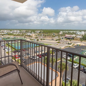 A cozy master balcony offers a view of the surrounding area, including parking lots and nearby tennis courts