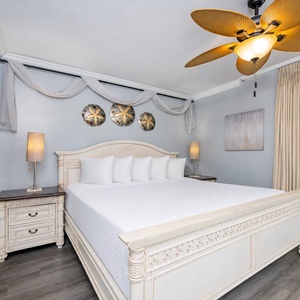King bed in the master suite invites restful nights beneath the tropical ceiling fan's gentle hum