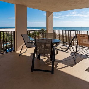 Enjoy relaxing moments on the spacious balcony with views of the sparkling water and nearby pool