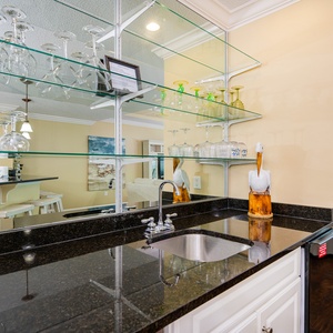 Unwind at the sleek wet bar, pouring your favorite drinks as you enjoy the soft glow of glassware