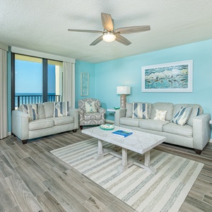 Bright sunlight fills the living room as you relax on soft couches with a soothing coastal view nearby