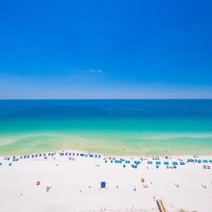 Enjoy the expansive beach view with colorful umbrellas and gentle waves, perfect for a relaxing day by the water