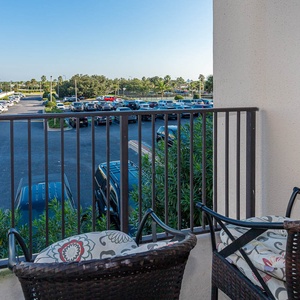 Have a relaxing moment on the balcony with comfortable seating and views of lush greenery and the parking area