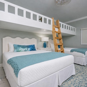 Playful retreat with two queen beds, a cozy loft with two twins, accessed by a wooden ladder, and fun decor