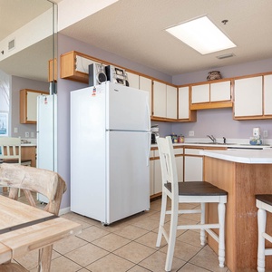 Bright kitchen area featuring white cabinetry, a breakfast bar with seating, and a view towards the dining space