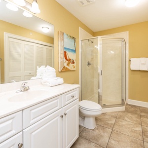 Additional bath featuring a walk-in shower, elegant vanity, laundry area with washer/dryer, and cheerful beach-themed artwork
