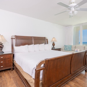 Master bedroom featuring a plush king bed, additional single beds, stylish decor, and a lovely view from the large windows