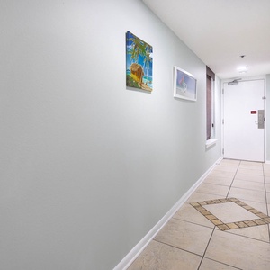 Step into a welcoming hallway adorned with vibrant artwork and stylish tile flooring, leading to your vacation retreat
