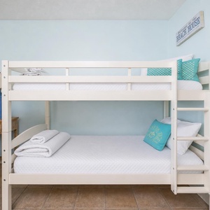 Soft pillows and crisp sheets invite restful nights in the bunk area of the living room