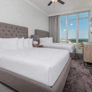 Wake to gulf views through floor-to-ceiling windows from two soft queen beds with upholstered headboards