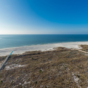 Expansive view of the tranquil beach with soft white sand and gentle waves, inviting relaxation and seaside adventures