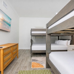 Rest in this guest room featuring sturdy full over queen bunk beds, a stylish dresser, and a TV