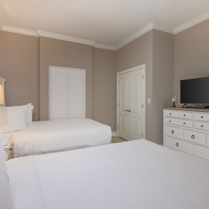 Rejuvenate in this guest bedroom with two queens inviting restful nights and joyful mornings