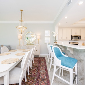 Settle onto teal-cushioned bar stools and enjoy the morning light in this elegant dining and kitchen area