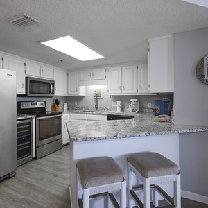 Kitchen featuring sleek stainless appliances, granite countertops, and a breakfast bar with seating