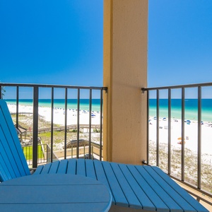 Relax on your balcony lounger while watching colorful umbrellas dot the white beach sand