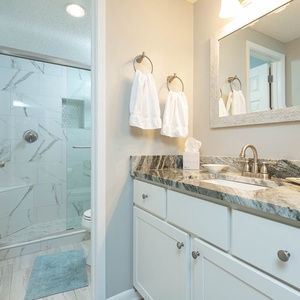 Bright and airy master bathroom featuring a walk-in shower, stylish fixtures, and a spacious vanity with ample storage