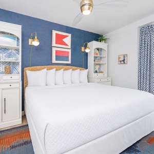 Relaxing guest bedroom featuring a plush king bed, stylish decor, and large windows with a vibrant view