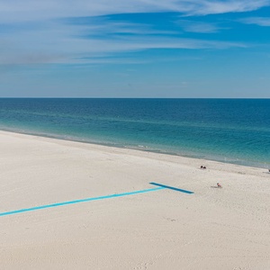 Breathtaking view of soft white sands meeting tranquil turquoise waters under a clear blue sky, perfect for relaxation