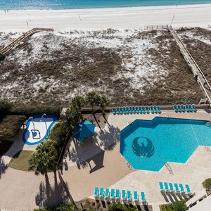 Take a refreshing dip in the inviting pool area, surrounded by palm trees and lounge chairs for ultimate relaxation